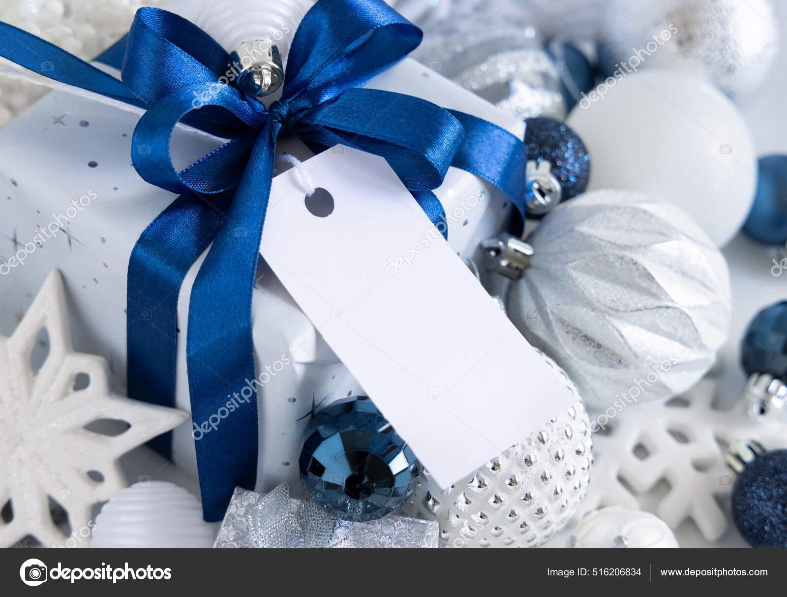 Christmas present with blue bow and silver decorations closeup