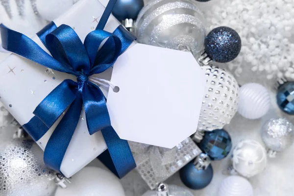 Обернутая Подарочная Коробка Голубым Бантом Бумажным Подарочным Биркой Белом Столе — стоковое фото