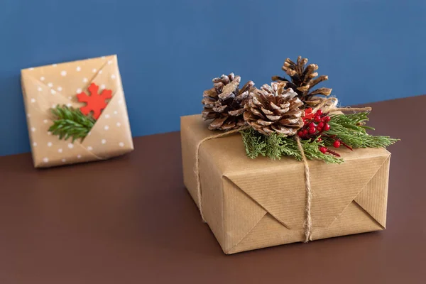 Wrapped Christmas Present Decorated Pine Cones Juniper Branches Brown Blue — Stock Photo, Image