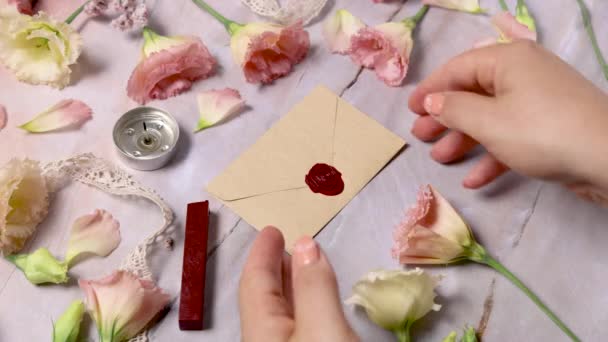 Eller Pembe Çiçeklerin Yakınındaki Mermer Bir Masadan Balmumu Mühürlü Zarf — Stok video