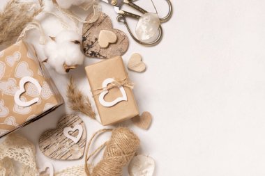 Sevgililer Günü hediyeleri kraft kağıdına sarılıp eski danteller, kalpler ve otlarla süslenmiş. Bahar kırsal, kır evi şıklığı veya bohem konsepti