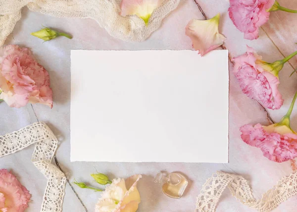 Ροζ Λουλούδια Και Μια Λευκή Ευχετήρια Κάρτα Ξαπλωμένη Ένα Μαρμάρινο — Φωτογραφία Αρχείου