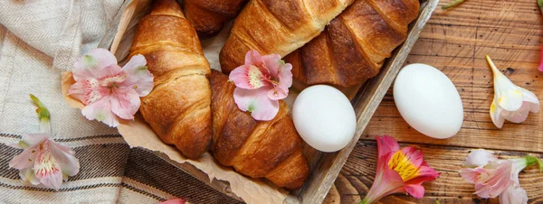 Verse Croissants Eieren Bloemen Een Dienblad Een Houten Tafelblad — Stockfoto