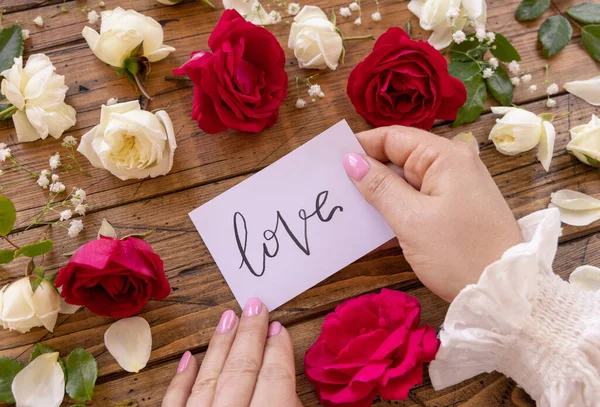 Hands Handwritten Card Love Surrounded Red Cream Roses Close Wooden — Fotografia de Stock