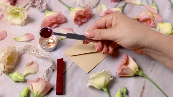 Hands Pouring Melted Wax Sealing Envelope Pink Flowers Marble Table — Stockvideo