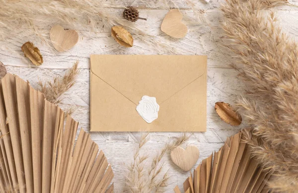 Blank Sealed Envelope White Wooden Table Dried Plants Palm Leaves — стоковое фото