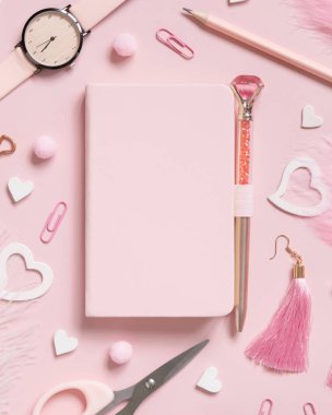 Hardcover defter, Pembe okul aksesuarları ve açık pembe renkli kalpler, Top view, ders kitabı modeli. Not defteri, makas, kalem, ataç, küpe ve saati olan kız işyeri. Okula geri dön. 