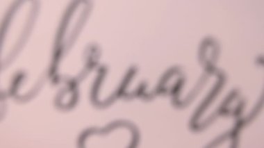 Eller kameradan uzaklaşsın. Bir FEBRUARY kartı.