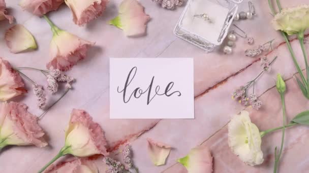 Tarjeta Love Una Mesa Mármol Cerca Flores Rosadas Vista Superior — Vídeo de stock