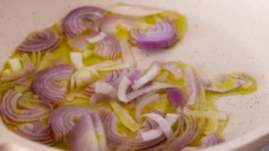 Kızarmış çiğ, mor soğanları tavada kızartıyorum. Isıtılmış zeytinyağı da yakınlaştırıyorum.