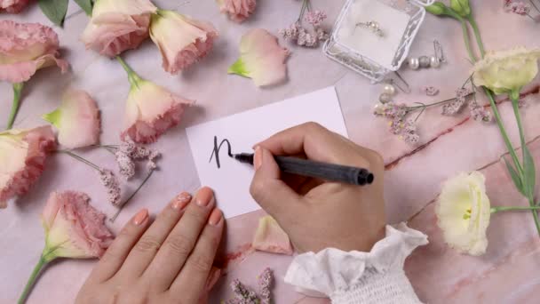 Mãos Escrevendo Mãe Dia Cartão Perto Flores Cor Rosa Perto — Vídeo de Stock