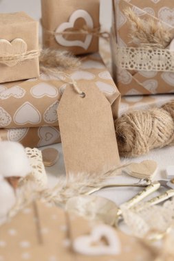 Sevgililer günü hediyelerini dikey hediye etiketleriyle paketlemişler. Boş etiketli bahar sahnesi. Kırsal, kır evi şıklığı veya bohem modeli, boşluğu kopyala