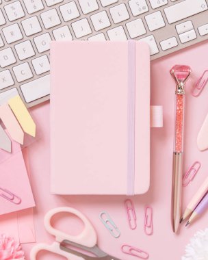 Hardcover defter, Pembe okul aksesuarları ve açık pembe klavye, Top view, ders kitabı modeli. Not defteri, makas, kalem, ataç, kart ve saati olan kız işyeri. Okula geri dön. 