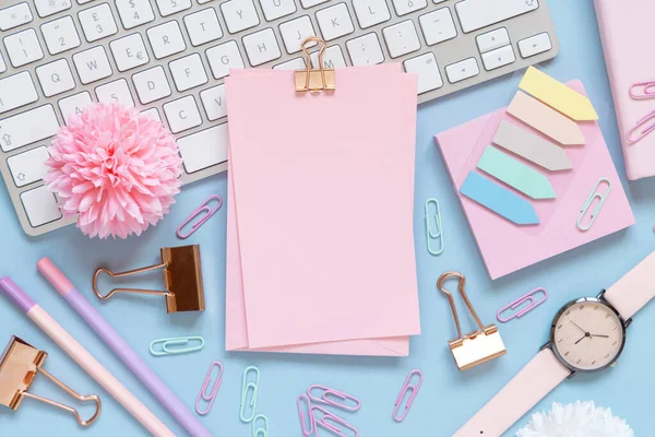 Şarjörü olan bir kağıt, Pembe Okul aksesuarları ve açık mavi üzerine klavye, Üst Manzara, Model. Not defteri, makas, kalem, ataç, kart ve saati olan kız işyeri. Okula geri dön. 
