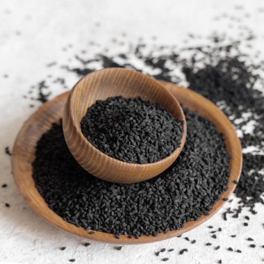 Hint baharatlı kimyon (nigella sativa veya kalonji) tohumları ahşap kaselerde yakındır. Geleneksel tıp, sağlıklı ve vejetaryen gıda konsepti.