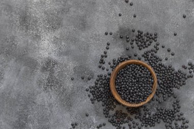 Gri masa manzaralı tahtadan bir kase siyah beluga mercimek fasulyesi. Sağlıklı beslenme, vegan ve vejetaryen beslenme için protein kaynağı. Geleneksel Asya ve Kuzey Afrika mutfak malzemeleri