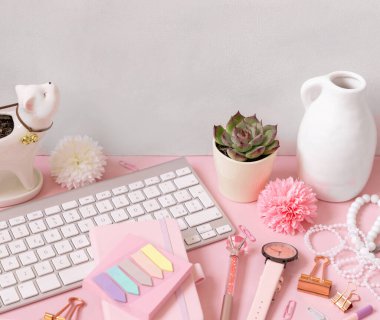 Açık pembe üzerine klavye ve pembe okul aksesuarları, kapatın. Çiçekli, klavyeli, kalemli, kalemli ve saatli kız işyeri. Okula geri dön. 