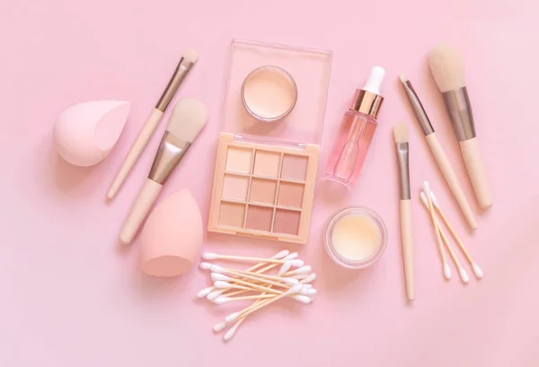 Skin care and makeup products on light pink, top view, banner. Flat lay with natural beauty products and decorative cosmetics. Everyday woman face care routine. Pastel composition
