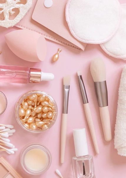 Skin care and makeup products on light pink, top view. Flat lay with natural beauty products and decorative cosmetics. Everyday woman face care routine. Pastel composition