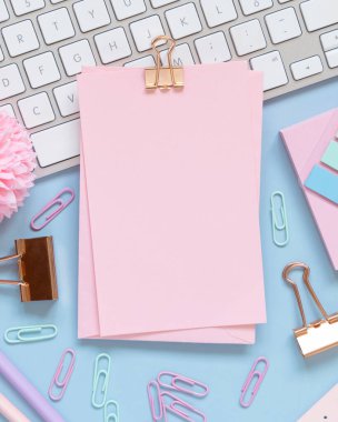 Şarjörü olan bir kağıt, Pembe Okul aksesuarları ve açık mavi üzerine klavye, Üst Manzara, Model. Not defteri, makas, kalem, ataç, kart ve saati olan kız işyeri. Okula geri dön. 