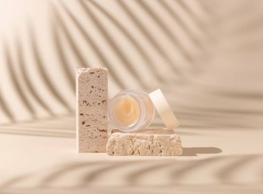 Smass Glass Cosmetic jar on travertine stones on light beige close up, palm leaf hard shadows. Skincare beauty product package. Exotic natural cosmetics, pastel minimal compositio