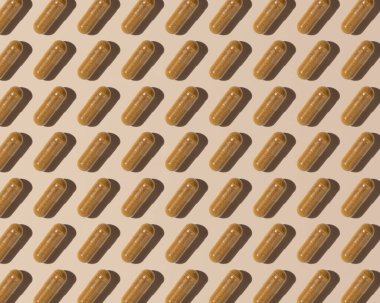 Capsules on light beige top view, hard shadows, creative pattern. Preventive medicine and healthcare, taking dietary supplements and vitamins.  Assorted pharmaceutical medicine capsules