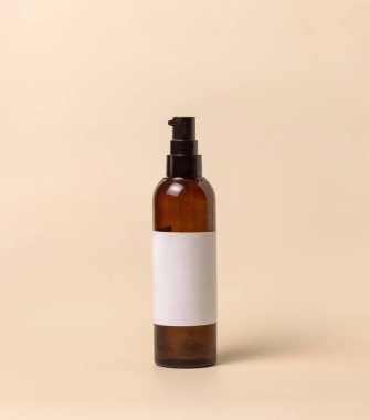 Cosmetic refillable One pump glass bottle with blank label on light beige, close up, Packaging mockup. Skincare beauty product, facial cleaner or lotion. Homemade Natural cosmetic