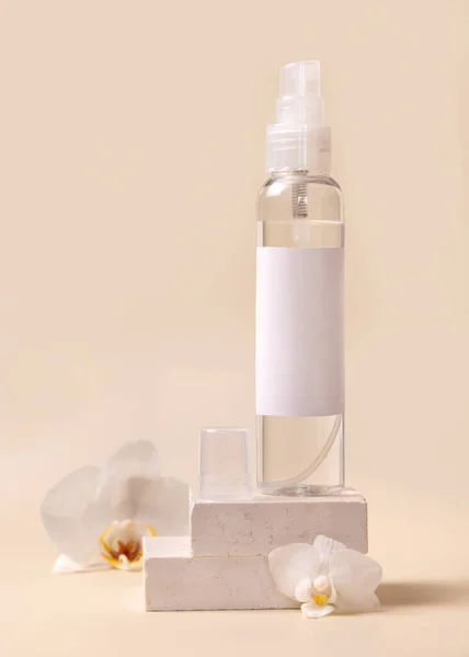 Σπρέι Μπουκάλι Διανομέα Κοντά Λευκά Λουλούδια Ορχιδέας Και Μπεζ Πέτρες — Φωτογραφία Αρχείου