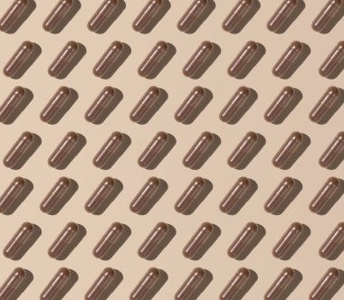 Capsules on light beige top view, hard shadows, creative pattern. Preventive medicine and healthcare, taking dietary supplements and vitamins.  Assorted pharmaceutical medicine capsules