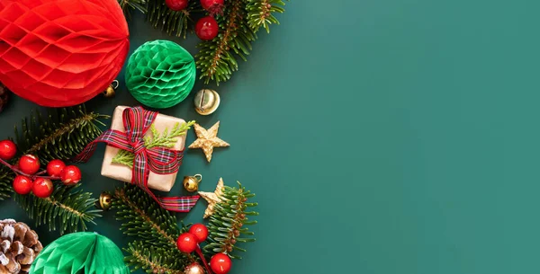 Border made of Wrapped gift boxes, Christmas decorations and green fir branches top view on green background, copy space. Christmas or New Year Holiday atmosphere flat lay