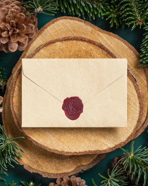 在冷杉树枝和松果之间的木片上贴上空白密封的信封 在绿色的顶部看 圣诞或新年贺卡模板 节日冬季作文 — 图库照片
