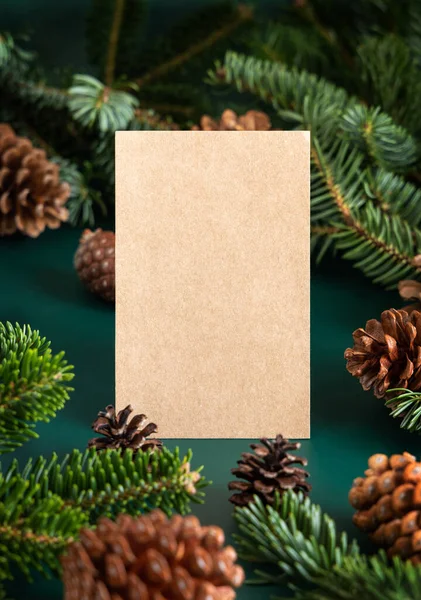 モミの枝と松の木のコーンの間の垂直空白のカードを閉じると モックアップ クリスマスまたは新年のグリーティングカードテンプレート ホリデー冬の組成 — ストック写真