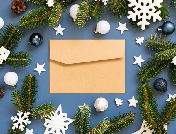 在白色圣诞装饰品和冷杉枝条旁边蓝色背景的手工纸制信封顶视图 复制空间新年和圣诞假期的气氛平平平静静 — 图库照片