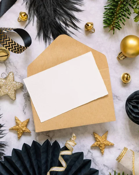 在黑色和金色的圣诞装饰和冷杉树枝之间的纸制卡片和信封 冬季平铺与空白邀请卡 燃烧室 复制空间 — 图库照片
