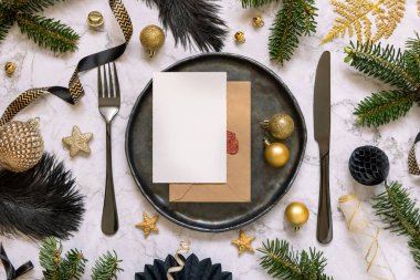 Süslü siyah ve altın masa seti ve köknar ağacı dalları üst görünüm, davetiye kartı modeli. Noel veya Yeni Yıl atmosferik bileşimi mermer masa üzerinde, kopyalama alanı. 