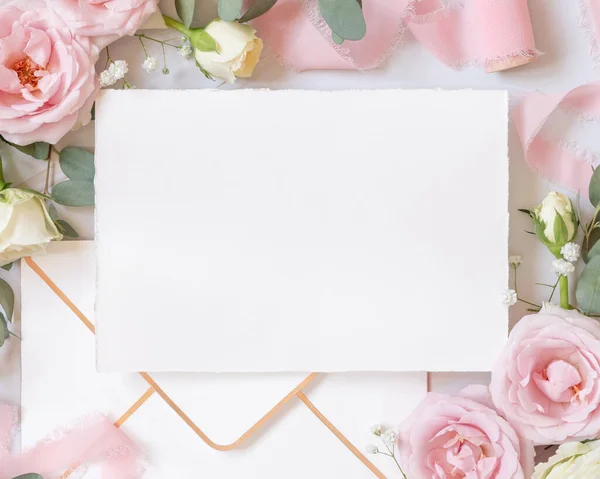 纸卡和信封之间的浅粉玫瑰和丝带的大理石顶部视图 婚礼模型 浪漫的场景 用空白卡片和油腻的花朵平铺着 情人节 春天或母亲节 — 图库照片