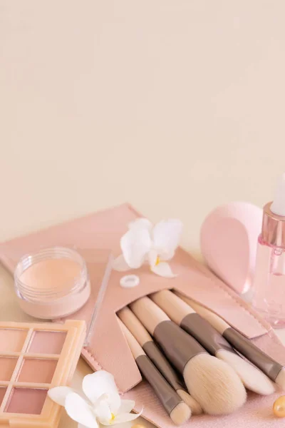 Skin care products and make up brushes on light beige close up, copy space. Natural beauty products and decorative cosmetics. Everyday woman face care routine. Pastel composition