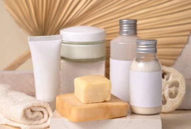 Küçük şişeler ve el yapımı sabun kalıpları kuru bej palmiye yaprağına karşı kapatılıyor. Etiket modeli. Cilt bakım ürünleri, krem ya da losyon. Doğal organik kozmetik. Asgari çevre dostu kompozit