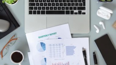 Laptop, sulu bitkiler, belgeler ve aletlerle dolu modern ofis masaüstü. Kahve fincanıyla üç aylık raporlar üzerinde çalışıyorum. Smark evde çalışıyor. Duraksama