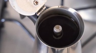 İtalyan moka tenceresini elinle çıkar. İtalyan moka demliğinde kahve yapma süreci.
