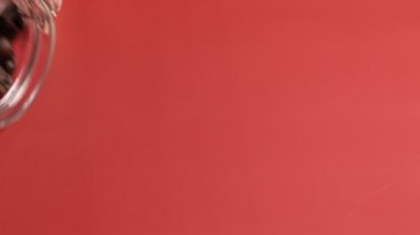 Kavanozlu cam kavanoz. Kahve çekirdekleri pembeye dökülüyor.