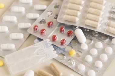 Alüminyum ve plastik kabarcıklardaki hap ve kapsüllerin karışımı ve açık bej kaplamalarda kullanılan kayıp haplar. Koruyucu ilaç ve sağlık hizmetleri, beslenme takviyeleri ve vitaminler almak