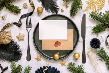 Süslü siyah ve altın masa seti ve köknar ağacı dalları üst görünüm, davetiye kartı modeli. Noel veya Yeni Yıl atmosferik bileşimi mermer masa üzerinde, kopyalama alanı. 