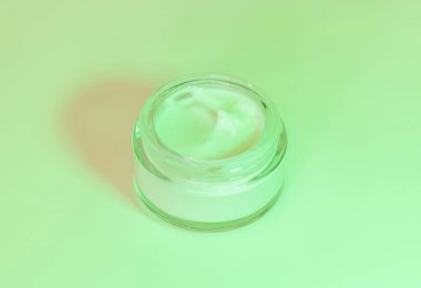 Krema kavanozunu kapat, Mockup. Yeşil ışık. Kozmetik ambalaj modeli. Tek renkli kompozisyon, günlük cilt bakımı