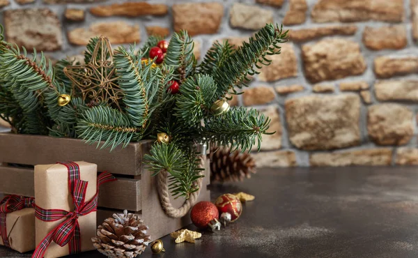 クリスマスの装飾の近くにギフトボックスを包んだ 松のコーンと緑のモミの枝は コピースペースで木製の背景に閉じ 閉じます クリスマスや新年の休日の雰囲気組成 — ストック写真