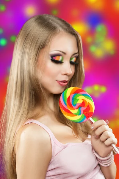 Chica con piruleta. un fondo colorido — Foto de Stock