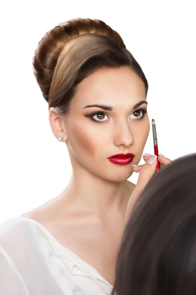 Beautiful girl applying make-up by make-up artist — Stock Photo, Image