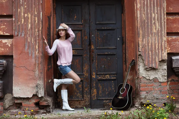 Girl with a guitar in an old building — Stock Photo, Image