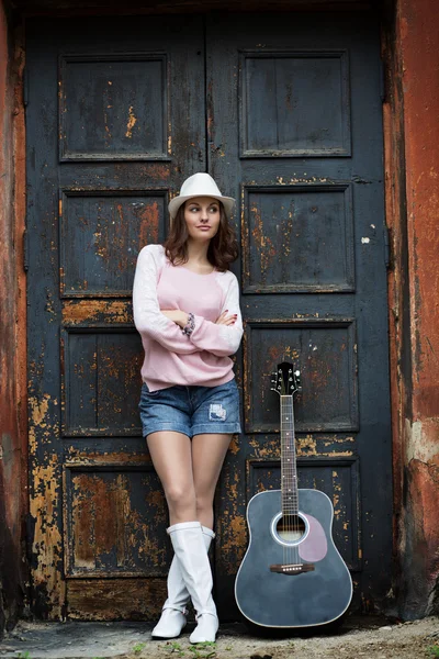 Menina com uma guitarra em um prédio antigo — Fotografia de Stock