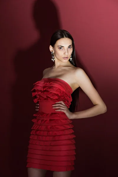 Beautiful brunette with  in a red dress — Stock Photo, Image